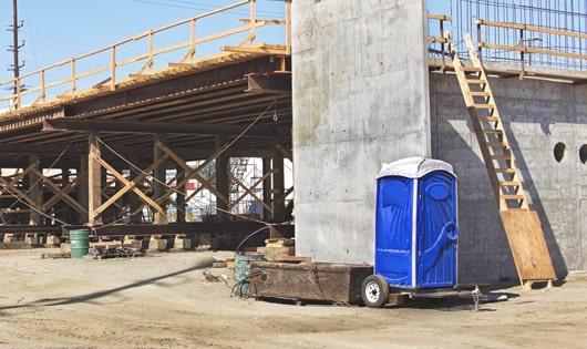 a row of blue portable toilets set up on a job site